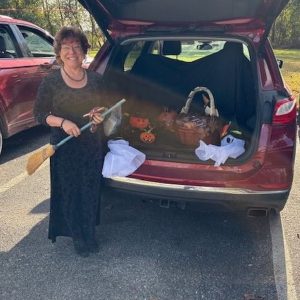 Guest dressed as a witch with a broom at a previous Trinity Trunk or Treat